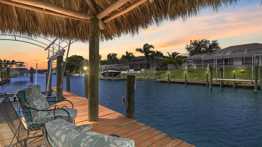 Villa Aleena - a tiki hut on a wide canal with lounge chairs overlooking the sunset - SWFL Vacation Rentals